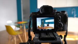 A camera on a tripod positioned in front of a kitchen setting.