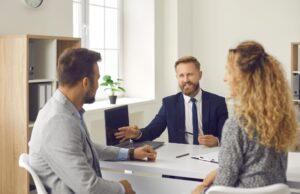 Homeowner discussing asking price strategy with estate agent during property valuation meeting