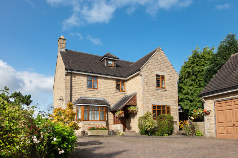 A large house with a garage and a paved driveway.