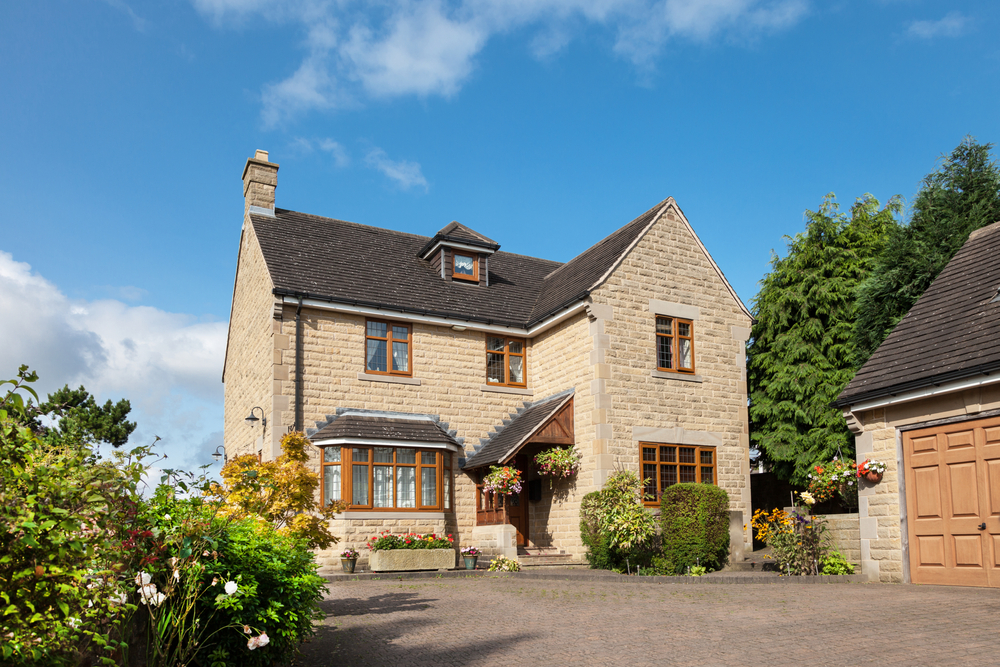 A large house with a garage and a paved driveway.