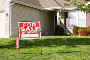 For sale by owner sign in front of a house.