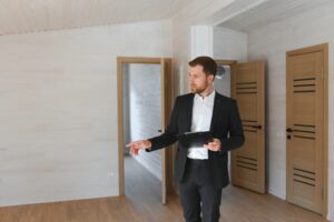 Man in a suit standing alone in a vacant room.
