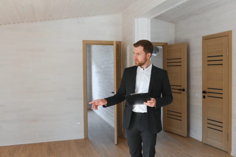 Man in a suit standing alone in a vacant room.