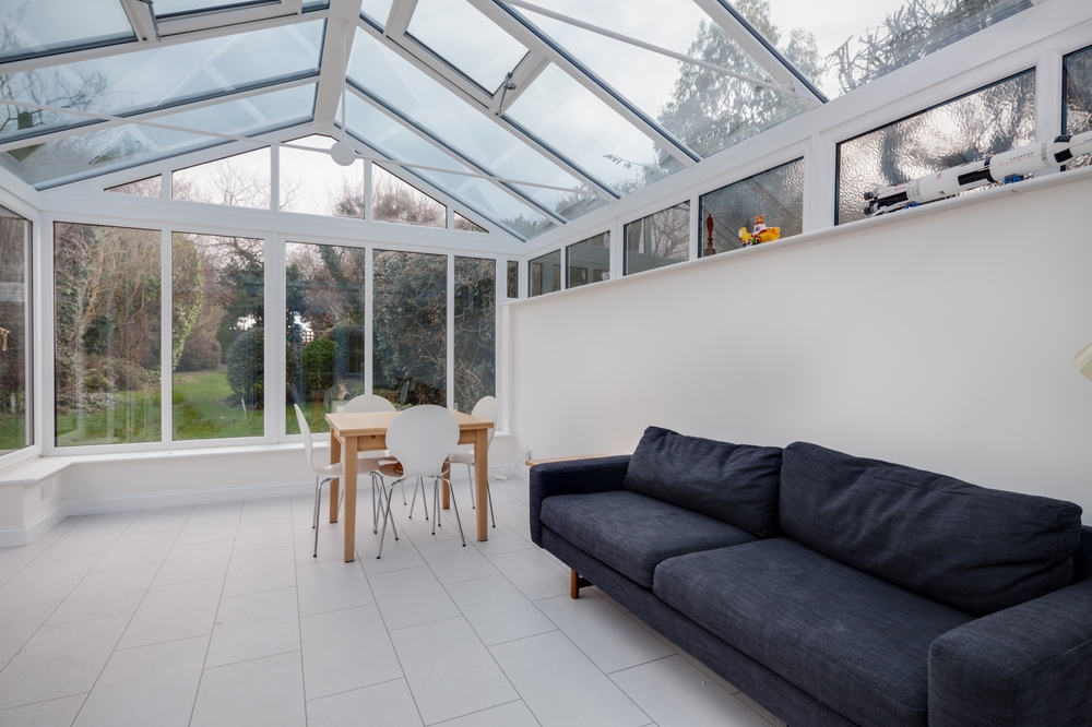 A sunroom featuring a spacious glass roof, allowing natural light to fill the space.