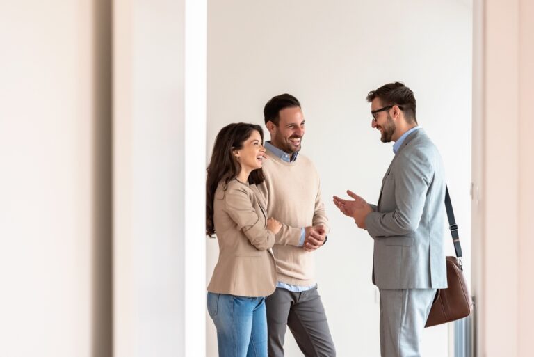 Estate agent discussing property options with a couple in an office.