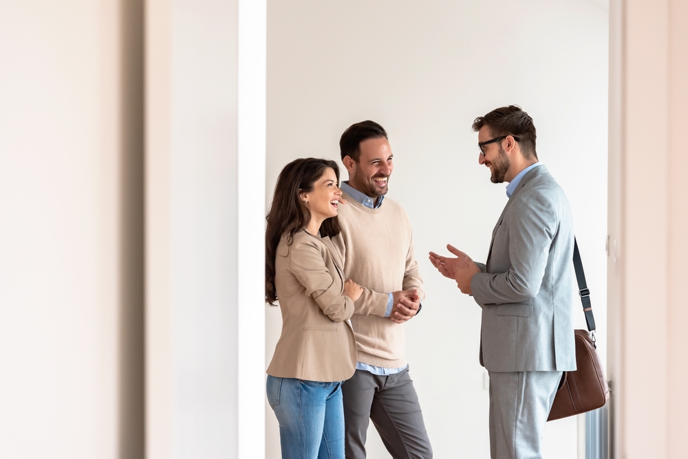 Estate agent discussing property options with a couple in an office.