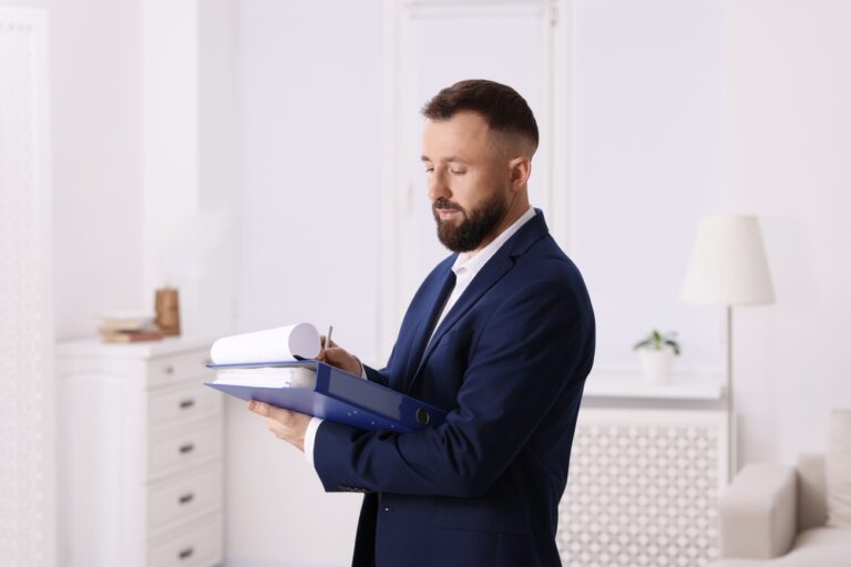 A man in a suit reviews a folder, assessing a property valuation.