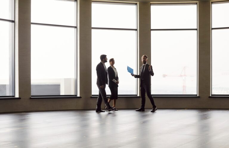 Three business people discussing in an empty room.