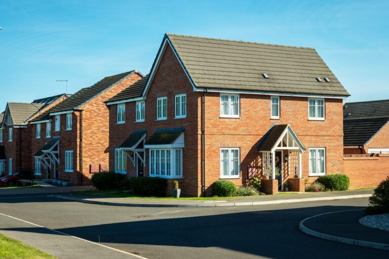 1. A row of colorful houses lined up along a street under a clear blue sky.