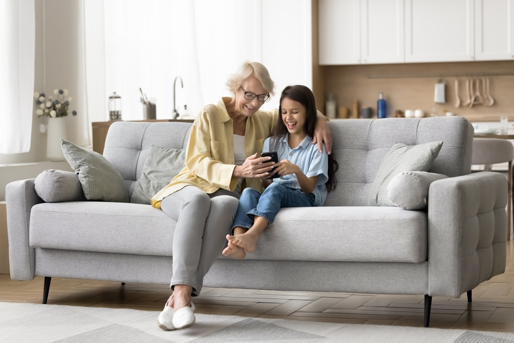 Older woman and young girl sitting together on a couch