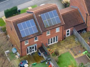 Aerial view of a house featuring solar panels on the roof.