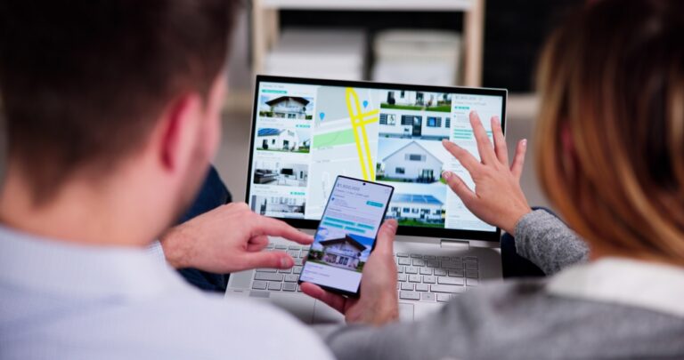 Couple examining a map on their laptop, planning their next destination.