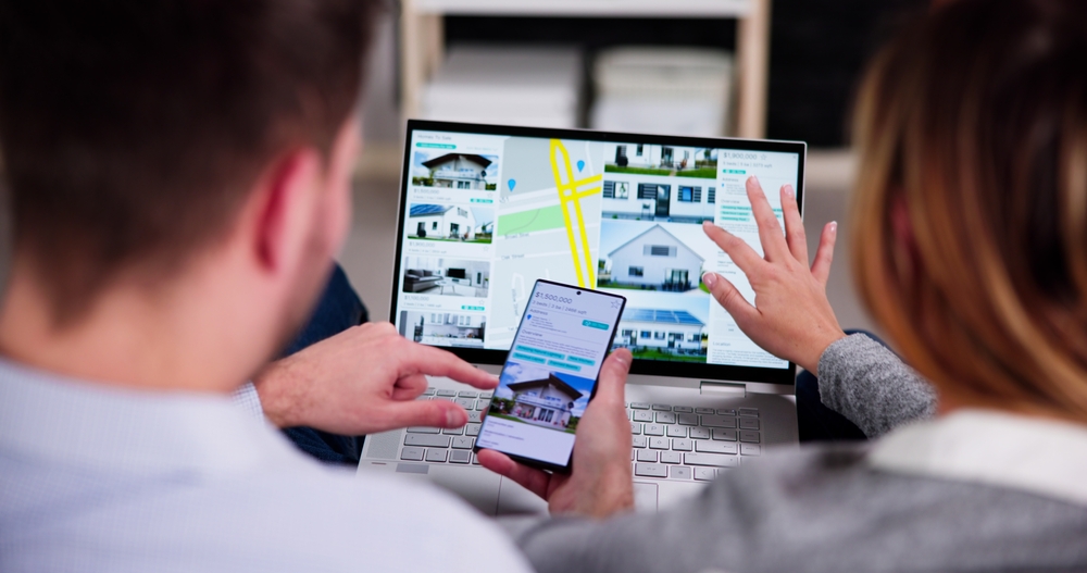 Couple examining a map on their laptop, planning their next destination.