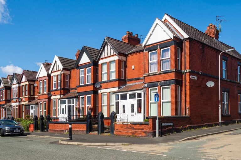 A row of colorful houses lined up against a clear blue sky.
