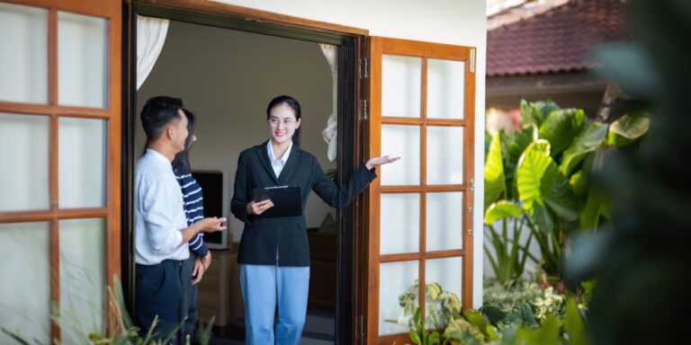 Asian couple discussing property with a real estate agent.